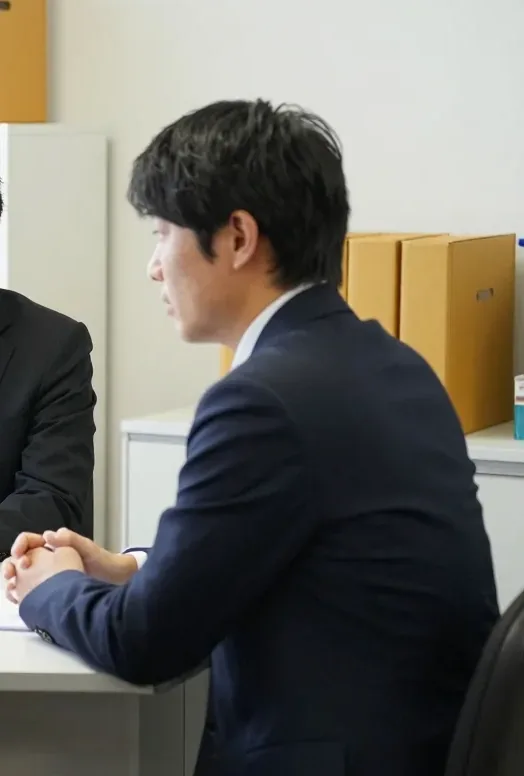 社長の会社の事務所で、机をはさんで話しているところ