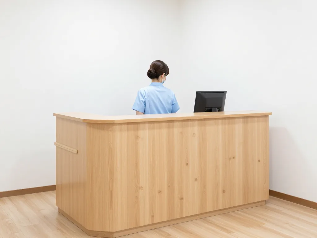 木の天板の受付カウンター。受付の人は後ろ姿