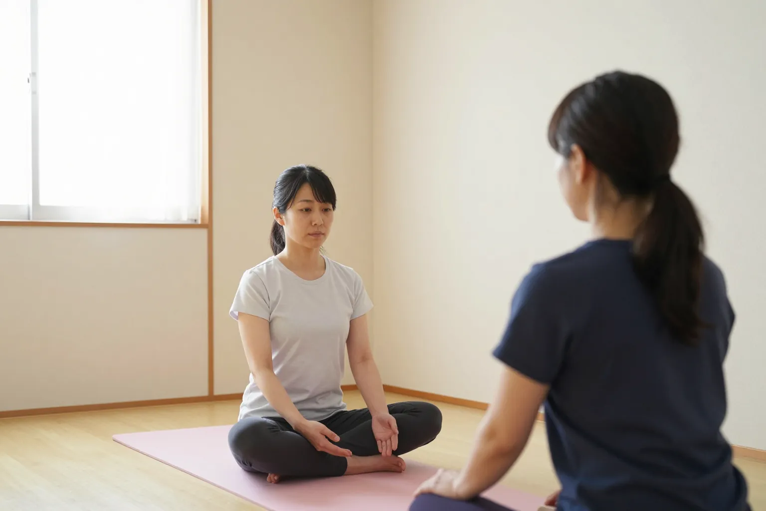 床に座って体操を見せている院長と、まねをする人